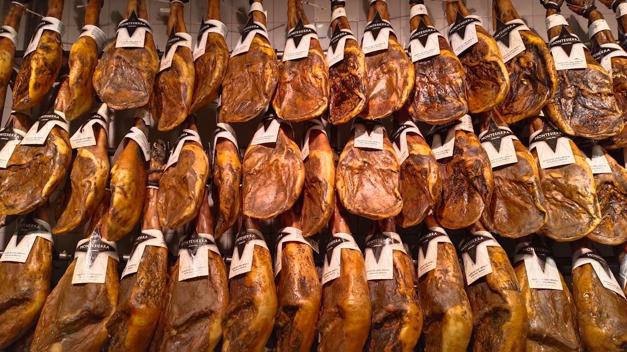 A display of jamón iberico hams hanging in a market. Traditional Spanish delicacy.